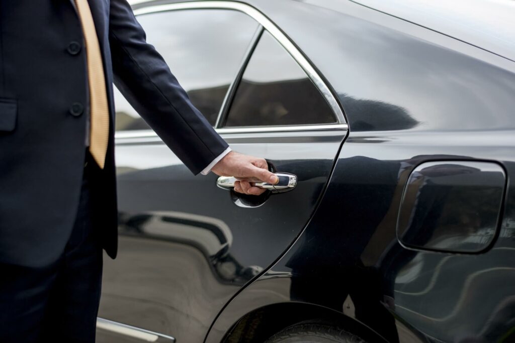 chauffeur opening a car door